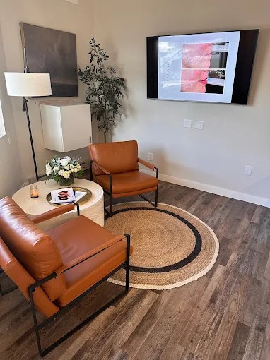 Waiting area inside the Spicer clinic with leather chairs and a woven rug